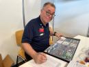 Bob Naumann, W5OV, SK, checking cards at the international amateur radio exhibition in Germany. 